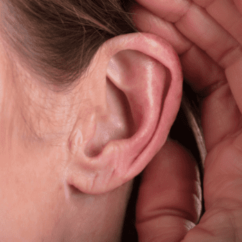 Eine Person hält sich die Hand ans Ohr, um besser hören zu können (Foto: AndreyPopov/Getty Images Pro via Canva).